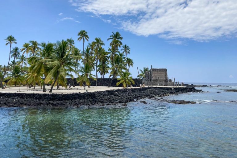 Palm trees and Hale o Keawe in Puʻuhonua o Hōnaunau National Historical Park, Hawaii