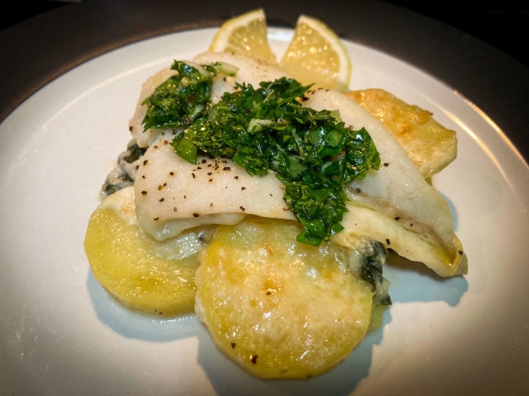 Halibut and scalloped potatoes with parsley gremolata on top