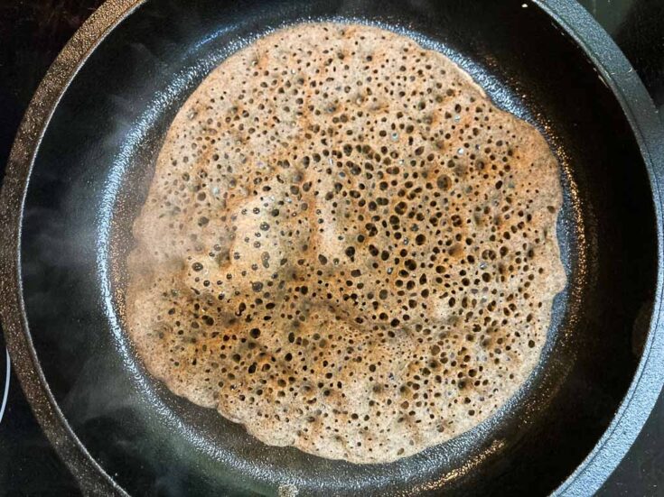 French-Acadian ploye pancake in a cast-iron skillet on stove