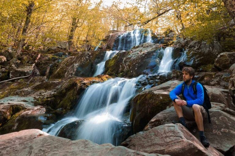 Hiker at Dark Hollow Falls in fall in Shenandoah National Park