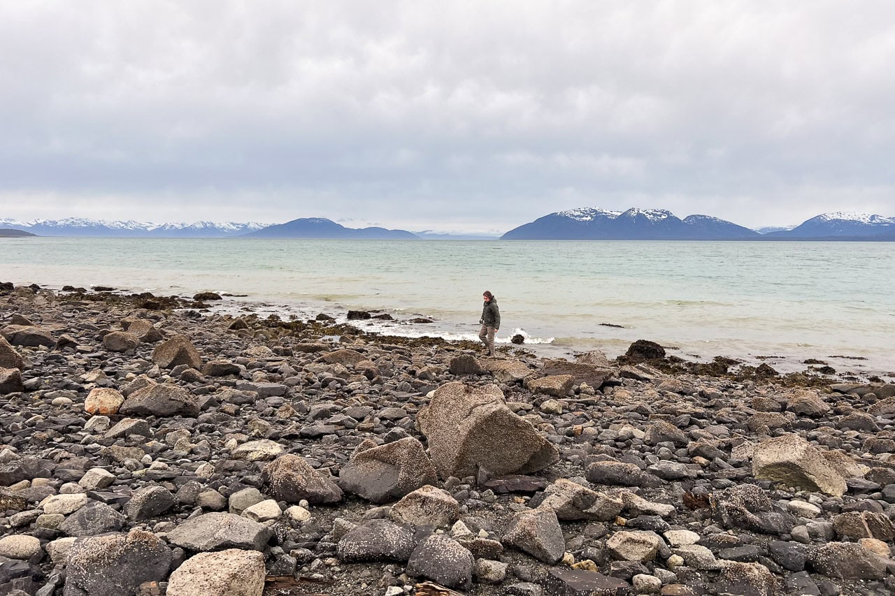 Visitor on the rocky shoreline in Bartlett Cove in Glacier Bay National Park, Alaska